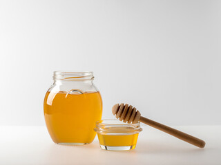 Natural organic honey in glass jar, honey dipper and honeycombs are near. Natural food background.