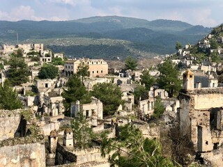 Fototapeta premium An abandoned ghost village in the hills of Turkey surrounded by mountains and trees