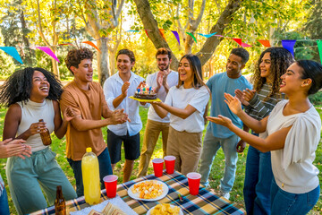 Happy woman celebrating birthday in a park with friends