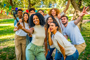 Multi-ethnic friends taking selfie embraced together in a park