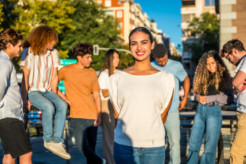 Fototapeta premium Beauty young woman standing smiling surrounded by friends at city