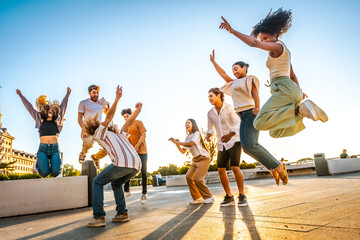 Friends jumping and dancing in the city during sunset