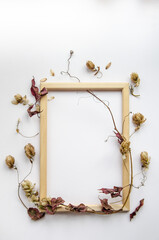 Autumn composition. Hop cones, dried leaves, wooden photo frame on white background. Autumn, fall concept. Flat lay, top view, copy space