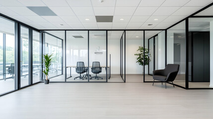 Modern office space with glass partitions, overlooking a landscape.  Suitable for showcasing minimalist design or coworking environments
