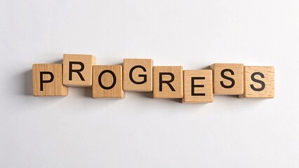 Alphabet wood blocks arranged to spell progress highlighting the importance of foundational concepts in business development and growth strategies.