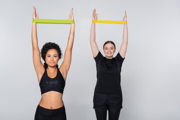 Strong women engaging in fitness exercises with resistance bands in a bright space