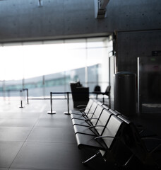 Empty airport seating in waiting area near departure gates in airport terminal. A travel concept symbolizing flight delays, departure lounge layovers, and the comfort of modern transit hubs