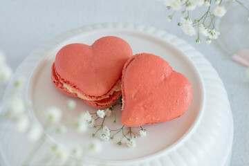 French macarons in the shape of red heart on light background, perfect for st Valentine's day and mother's day 