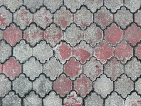 Curvy ornamental outdoor paving stone tiles, dark grey and pink color. Weathered and rusty paving stone in classic ornamental pattern. Pavement outdoor stone tiles. Seamless background texture.