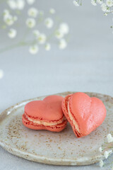 French macarons in the shape of red heart on light background, perfect for st Valentine's day and mother's day 