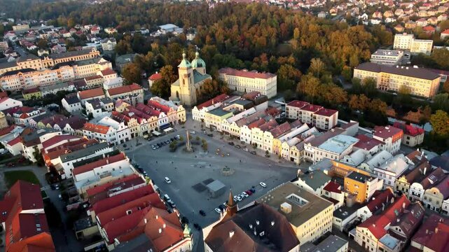 An aerial view of the charming architecture of a small Czech town, captured by a drone. The scene showcases traditional buildings, cobblestone streets, and historic landmarks, highlighting the town's 