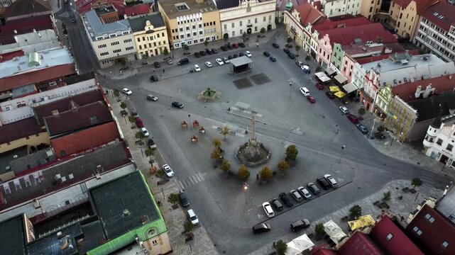 Drone video of a picturesque Czech town with red-tiled roofs and historic churches. Aerial view captures the charming architecture, narrow streets, and timeless beauty of the city.