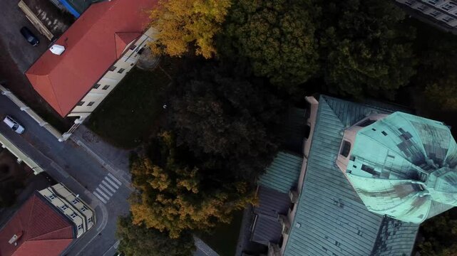 An aerial view of the charming architecture of a small Czech town, captured by a drone. The scene showcases traditional buildings, cobblestone streets, and historic landmarks, highlighting the town's 