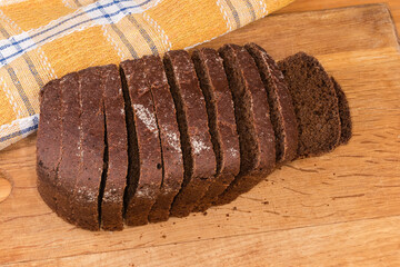 Sliced dark rye and wheat brown bread on cutting board