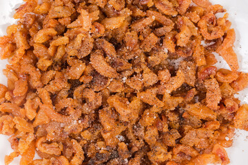 Heap of duck сracklings with salt and pepper, top view