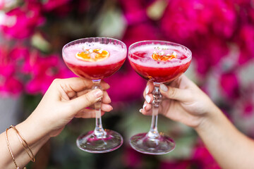 Close-up of female hands with elegant glasses. Women raise goblets with delicious fragrant berry...