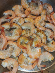 Cooking shrimp in a pan during a warm summer evening in bibione, italy, capturing the essence of mediterranean cuisine and flavor