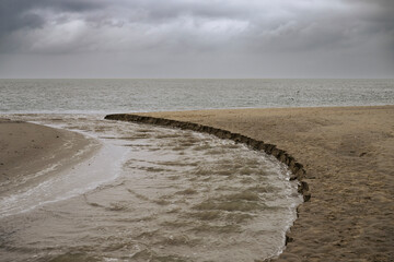 Curved Water Channel on a Cloudy Beach, De Cocksdorp, Texel, Netherlands