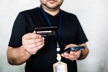 Man using phone and credit card for online shopping. Use credit card in office for business, startup or loan. Guy with online shopping, app or e commerce, payment with credit card at office