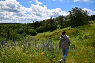 young woman wearing sport clothes walking in the meadow
