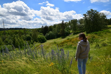 young woman wearing sport clothes walking in the meadow