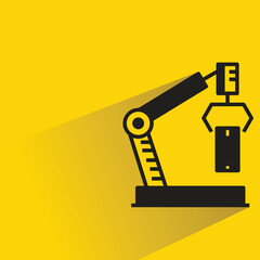 robotic arm picking box icon with shadow on yellow background