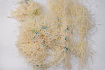 Raw kataifi dough with green and yellow mold in a glass container. Spoiled pastry dough with visible fungal contamination. Food spoilage and hygiene concept.