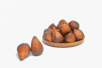 Top view of snake fruit in a wooden bowl isolated on a white background. Typical tropical fruit .Snake fruit skin is brown and scaly. Copy space for text. For graphic design or banner background