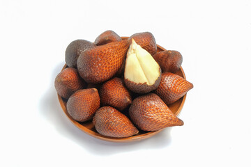 Top view of snake fruit in a wooden bowl isolated on a white background. Typical tropical fruit .Snake fruit skin is brown and scaly. Copy space for text. For graphic design or banner background
