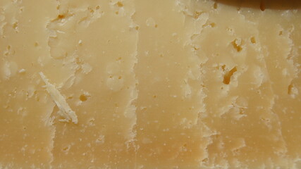 Hard cheese Malga extra aged close-up texture, cheese from cow's milk alpine, yellow cheese texture, Italy