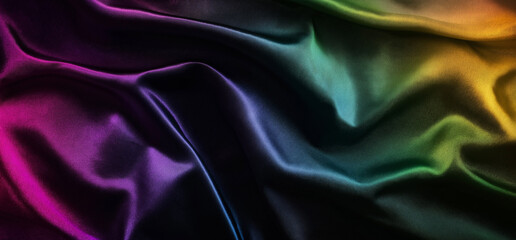 Fototapeta premium A dark, textured background featuring a gradient of rainbow colors, evoking modern design and fashion photography. The soft fabric-like texture, reminiscent of silk or velvet, creates an atmosphere of
