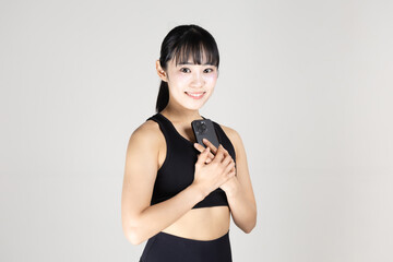 Naklejka premium スマートフォンを手に持っているスポーツウェアの女性