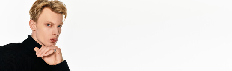 Young handsome man exudes confidence in a minimalist studio setting with striking expression