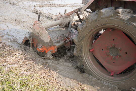A tractor with a rotavator attachment for plowing the agricultural field