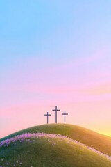 Obraz premium Tranquil scene of three crosses on a grassy hillside at sunrise, with a sky painted in soft pastel colors, symbolizing hope and serenity