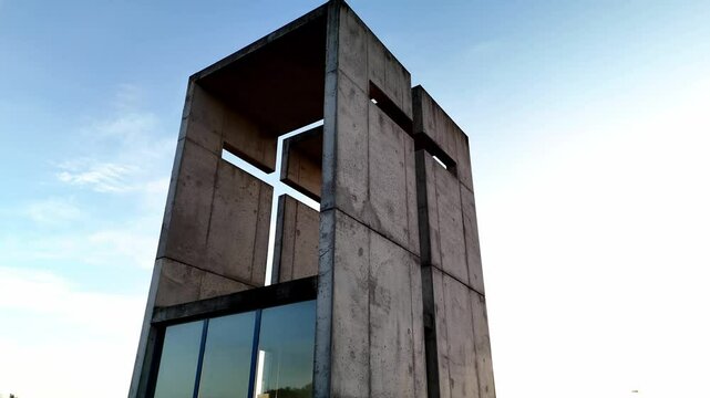 A mesmerizing aerial video of a small chapel beautifully illuminated by the golden sunset. The warm sunlight enhances the architectural details, creating a breathtaking contrast between the sacred str