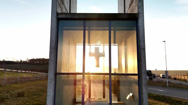 A mesmerizing aerial video of a small chapel beautifully illuminated by the golden sunset. The warm sunlight enhances the architectural details, creating a breathtaking contrast between the sacred str