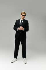 Confident young man in a stylish suit, sunglasses, and sneakers stands out in a modern space