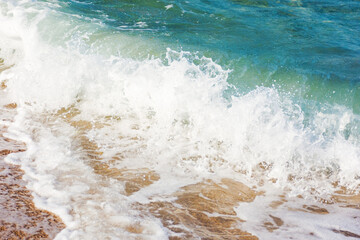 sea foam on the sandy beach. closeup nature background on a sunny afternoon. summer vacation season