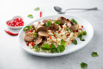 Homemade sausages with rice and pomegranate seeds