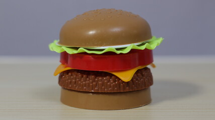Plastic hamburger burger isolated on grey background. Artifical junk food concept
