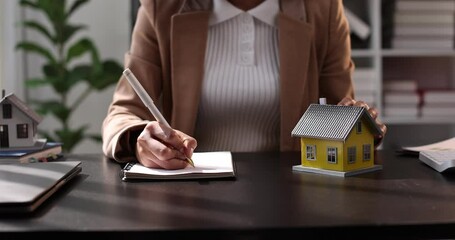 Female woman hands holding home model, small miniature white toy house. Mortgage property insurance dream moving home and real estate concept