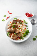 Homemade sausages with rice and pomegranate seeds