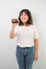 Beautiful young asian woman with wavy hair wearing white shirt is a dummy credit card, isolated over white background.