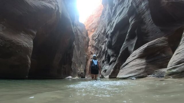 Female Traveler Walking Through the Virgin River in The Narrows, Zion National Par