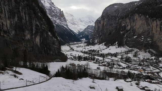 Lauterbrunnen Valley and Snowy Mountains on Cloudy Winter Day. Swiss Alps. Switzerland. Aerial View. Moving Forward, Tilt Up. Reveal Shot