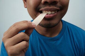 Close up of Asian brown man biting chewing bubble gum