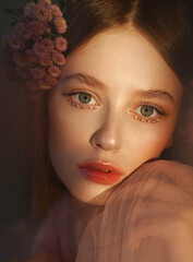 Close romantic art portrait of a girl with flowers in her hair.