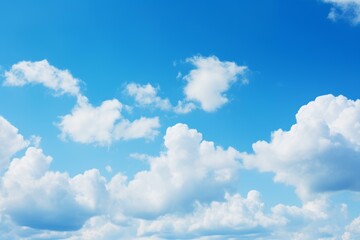 Fototapeta premium Beautiful white clouds drift across a vibrant blue sky, creating a serene and peaceful atmosphere