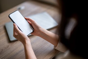 A woman is holding a cell phone in her hand